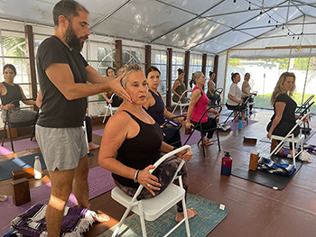 a man helping a yoga class